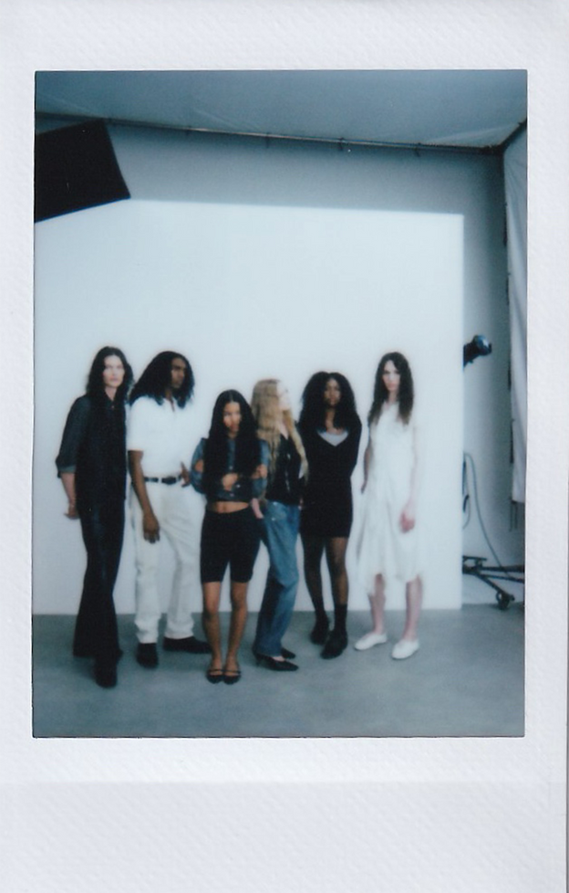 Polaroid of the mes° cast standing together in a photo studio.
