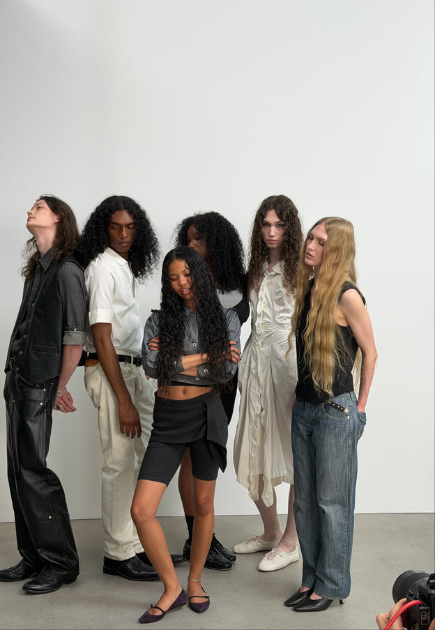 Six people from the mes° campaign cast standing together in a studio.