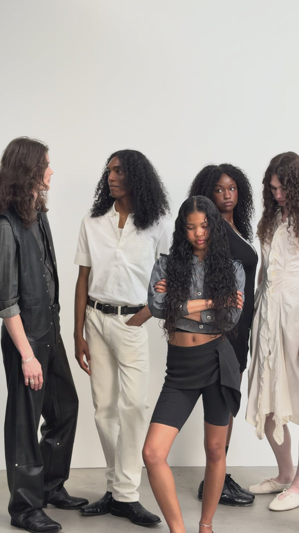 The mes° cast standing together in a studio.